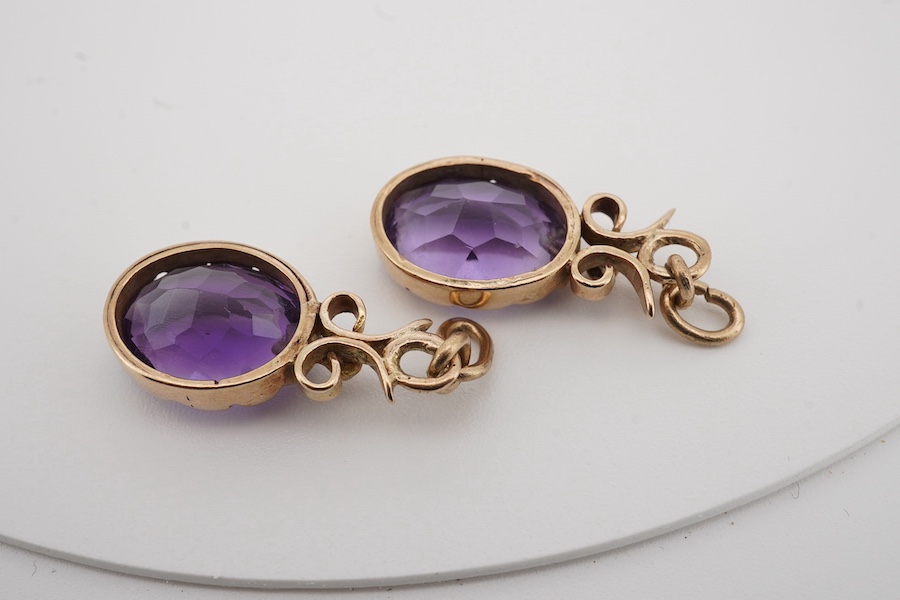 A pair of yellow metal and oval cut amethyst set drop earrings, lacking fittings, overall 28mm. Condition - poor to fair